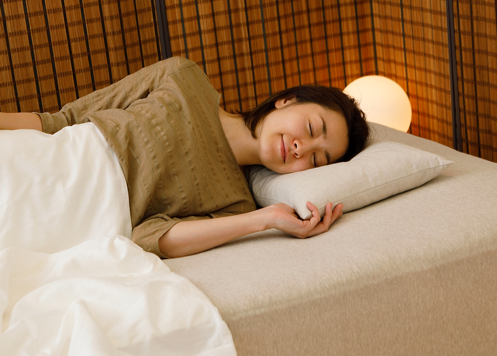 秋田杉の香枕で女性が眠っている